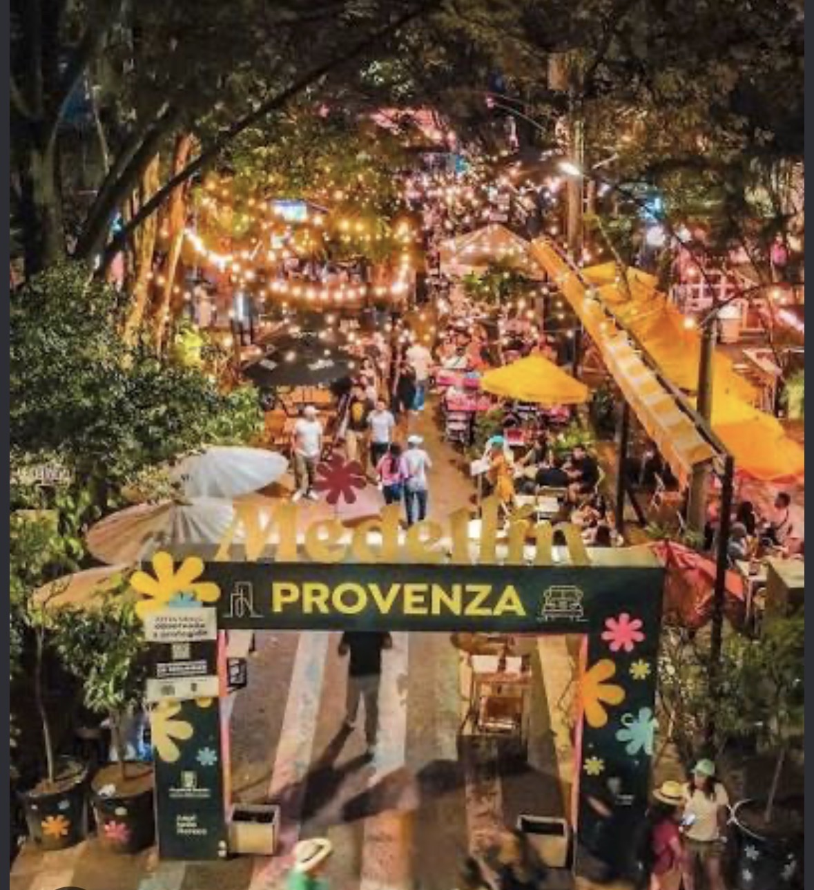 Provenza 's avonds, met lichtslingers, volle terrassen en het Provenza-bord op de voorgrond